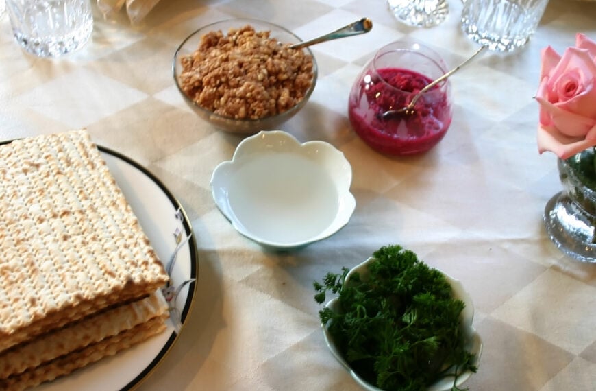 a table set for a Passover seder and the Worth Beyond Rubies logo at the bottom of the image