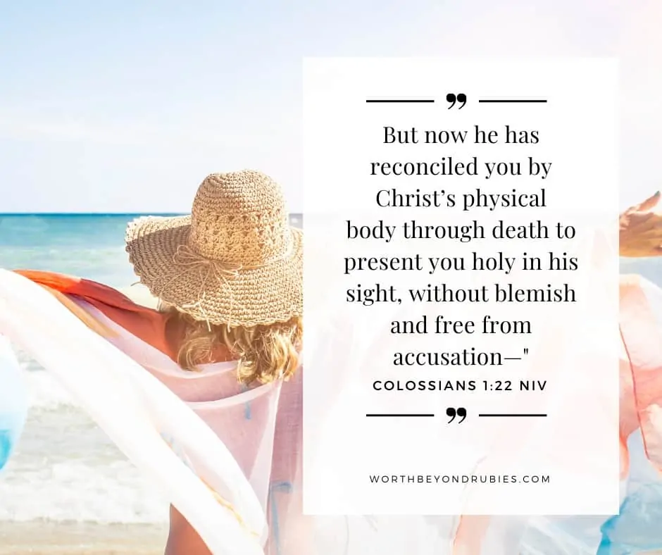 A woman on a beach with a wrap spread over her outstretched arms and Colossians 1:22 quoted