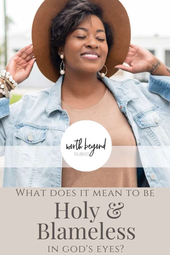 An image of a black woman standing outside in a jean jacket and a brown hat smiling and a text overlay that says What Does it Mean to be Holy and Blameless in God's Eyes?