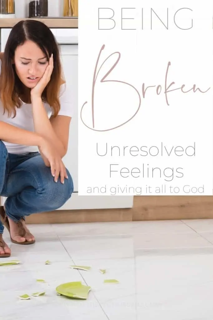 A woman squatting down on the floor looking at a broken plate with a text overlay that says 'Being Broken - Unresolved Feelings and Giving it All to God'