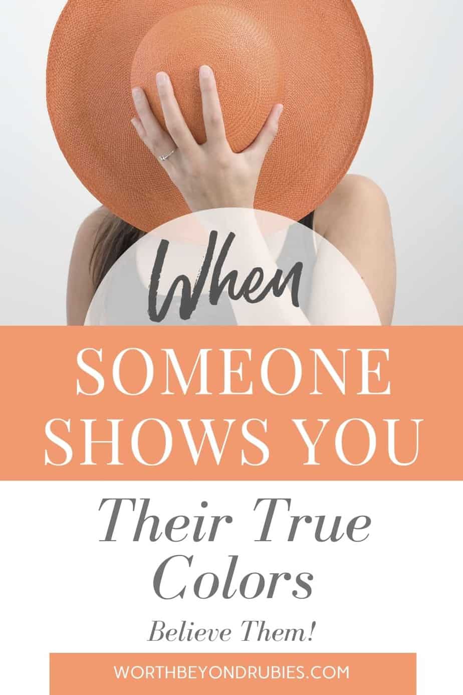 An image of a woman holding a large brimmed orange hat up in front of her face to hide it and text that says When Someone Shows You Their True Colors, Believe Them