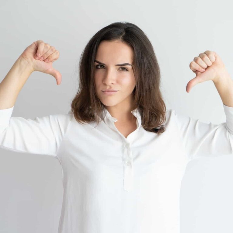 An image of a brunette woman in a white shirt with her thumbs pointing at herself - The Spirit of Pride