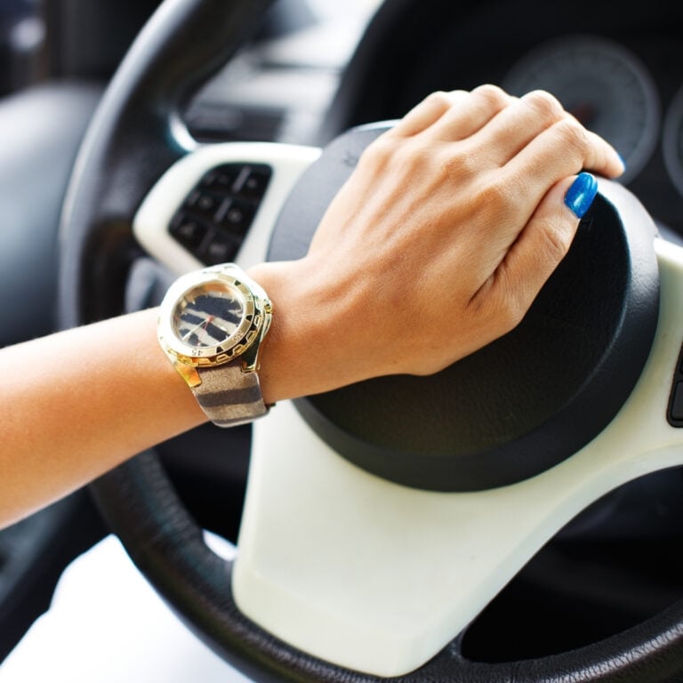 An image of a woman's hand showing a lime green sleeve and an animal print watch and she has her hand on the horn of her car for post called Giving Grace to Others - Driving Me Crazy!!