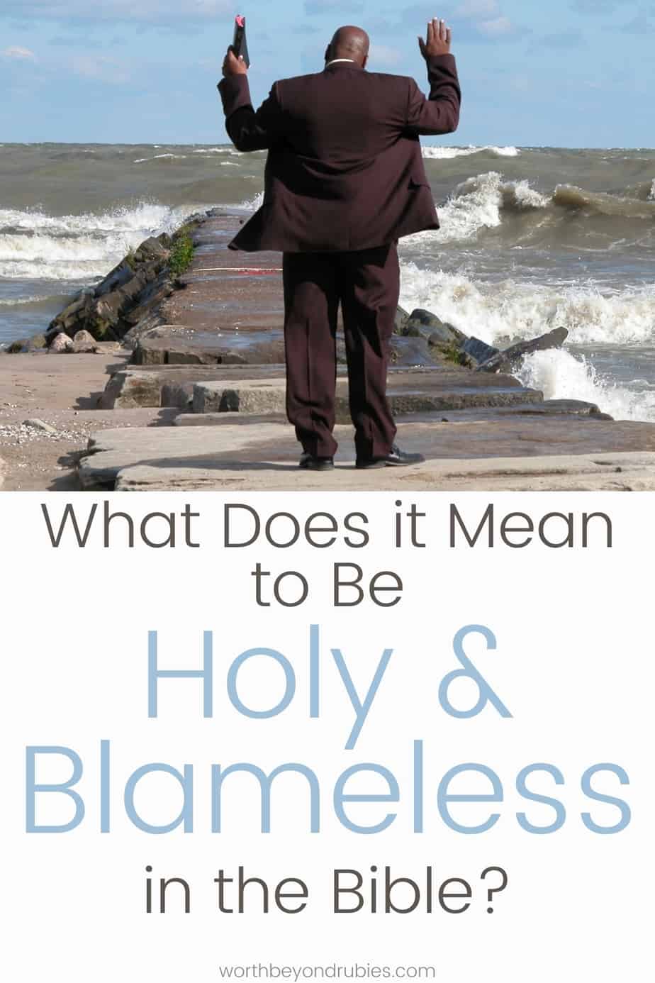 What Does it Mean to Be Holy and Blameless in the Bible? 1 A man in a suit on a pier at the beach with a Bible and his hands up in praise with text that says What Does it Mean to Be Holy and Blameless in the Bible?