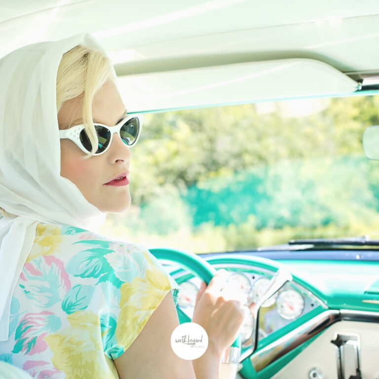 A woman in 1950s type clothing sitting behind the wheel of an antique car - for post titled Give it to God - 6 Powerful Ways to Let Go and Let God Handle It