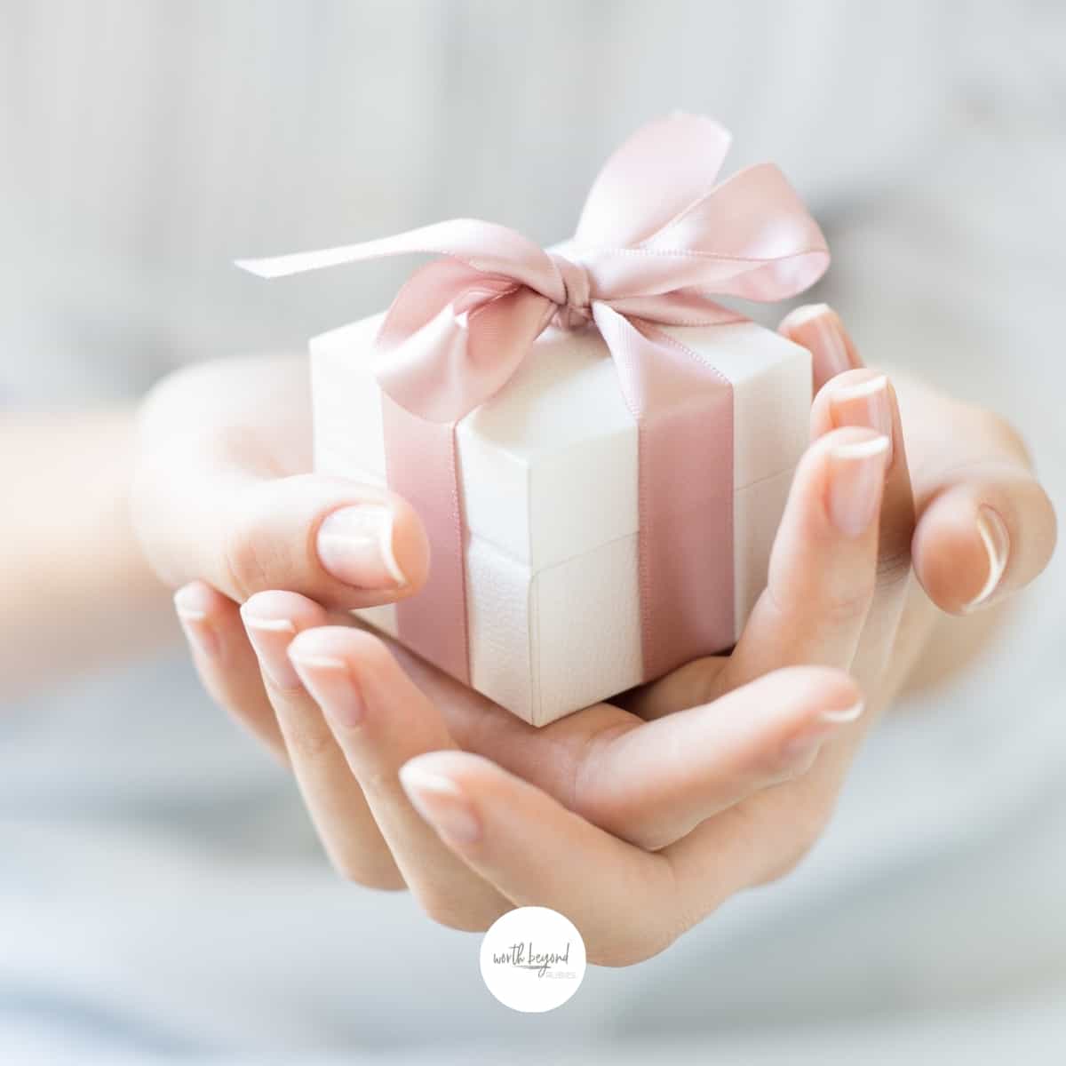 an image of a woman's hands holding a white gift box wrapped in pink ribbon - for post titled Do You Question Your God Given Gifts and Talents
