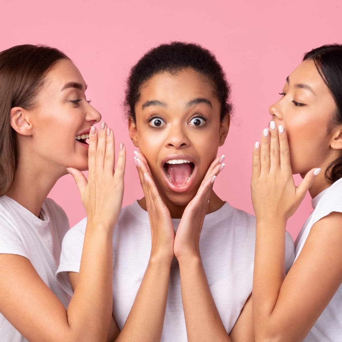 a group of women whispering into their mouth