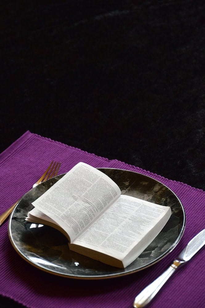 What is a Daniel Fast, Its Benefits, and How to Do It 3 image of Bible on plate with utensils for the post on what is a daniel fast