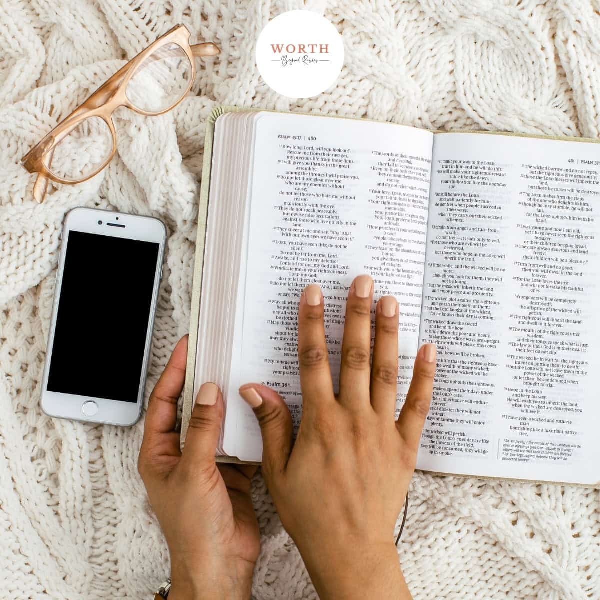 a person reading a Bible next to a phone