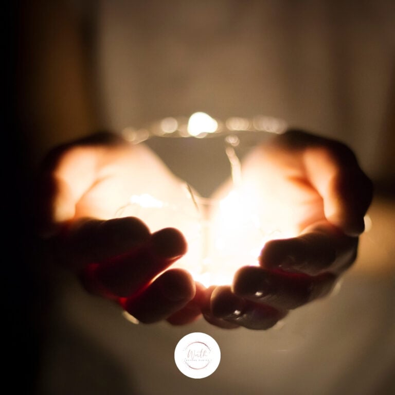 a person holding a glass with a light in their hands