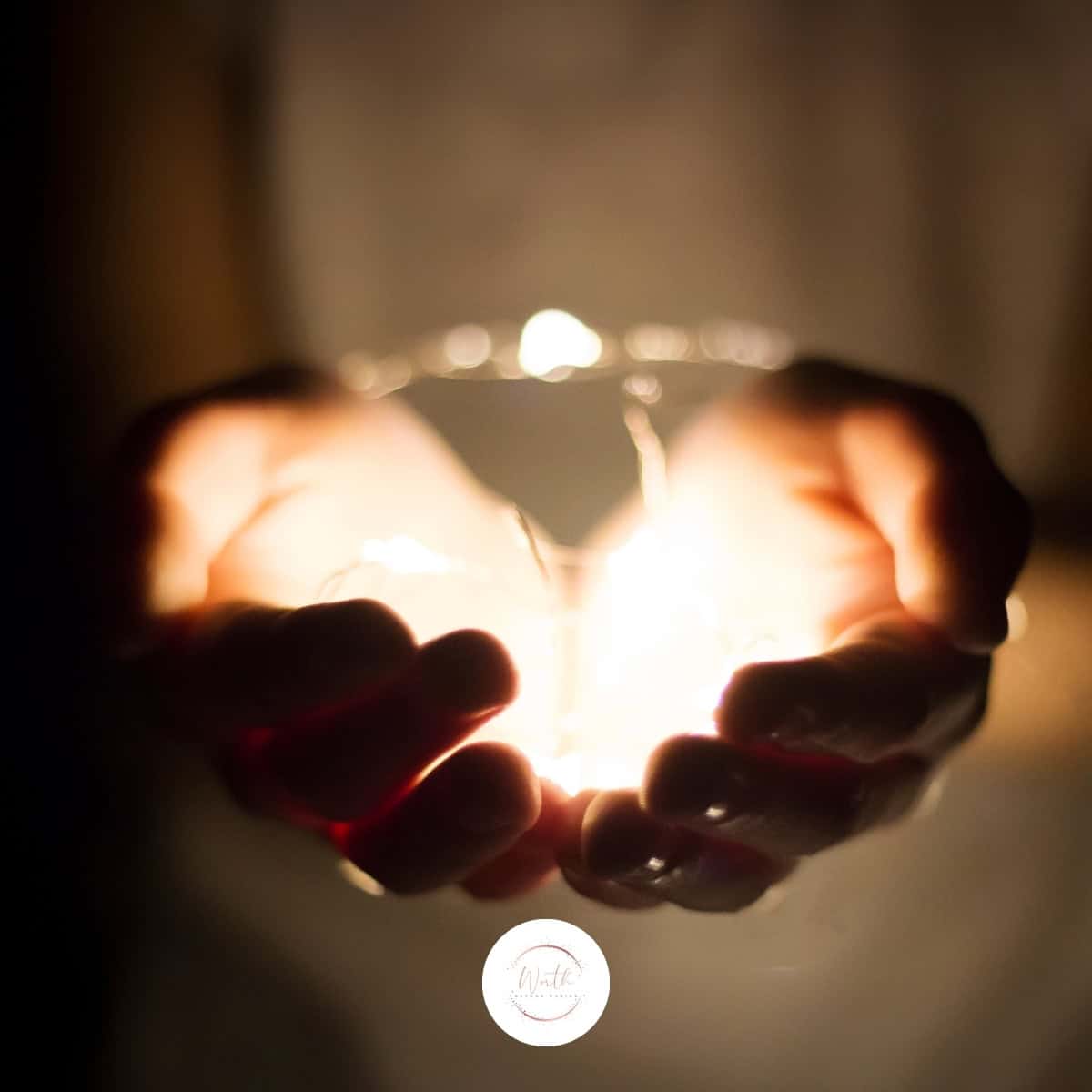 a person holding a glass with a light in their hands